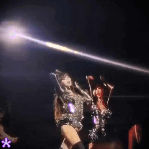 a woman is dancing on a stage with a purple star in the background
