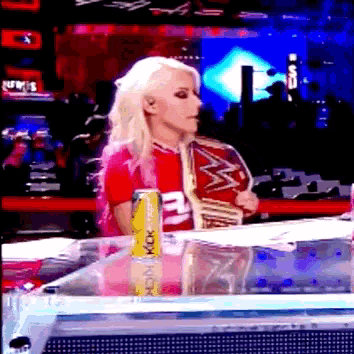 a woman sitting at a table with a can of energy drink next to her