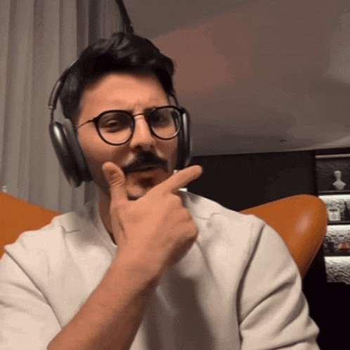 a man wearing glasses and headphones is making a face