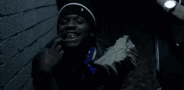 a man is holding a stack of money in his mouth .