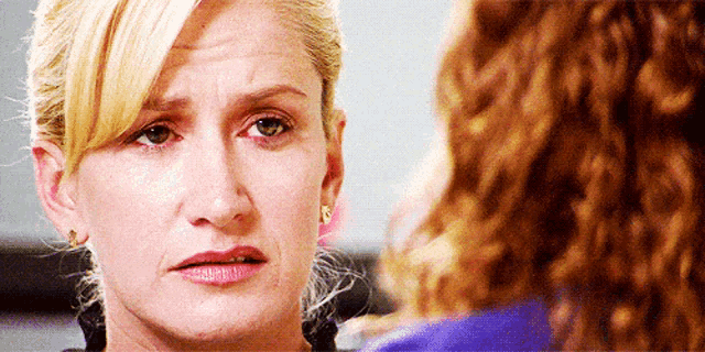a close up of a woman 's face with a tear running down her cheek .