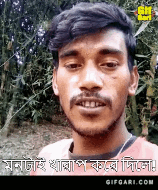 a man with a beard is making a funny face in a forest .