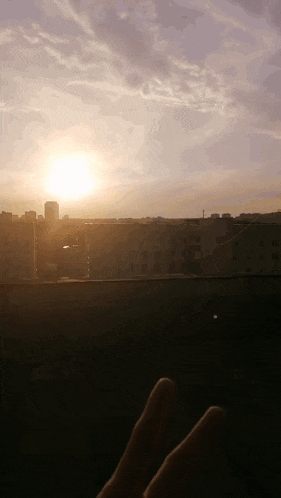 a person 's feet are visible in the foreground and the sun is setting in the background