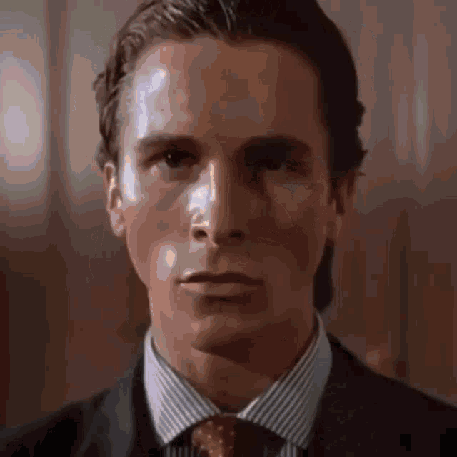 a close up of a man wearing a suit and tie .