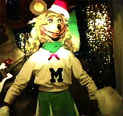 a mickey mouse mascot is wearing a santa hat