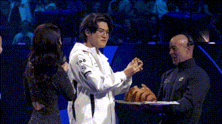 a man is holding a croissant in front of a woman and another man