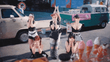 a group of women standing in front of an ice cream cart that says donuts