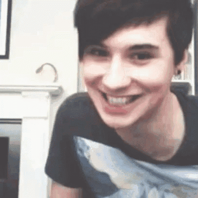 a young man is smiling while wearing a black t-shirt .