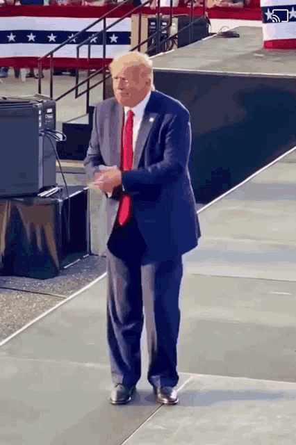 a man in a suit and tie stands on a stage