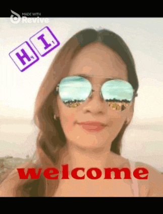 a woman wearing sunglasses and a welcome sign