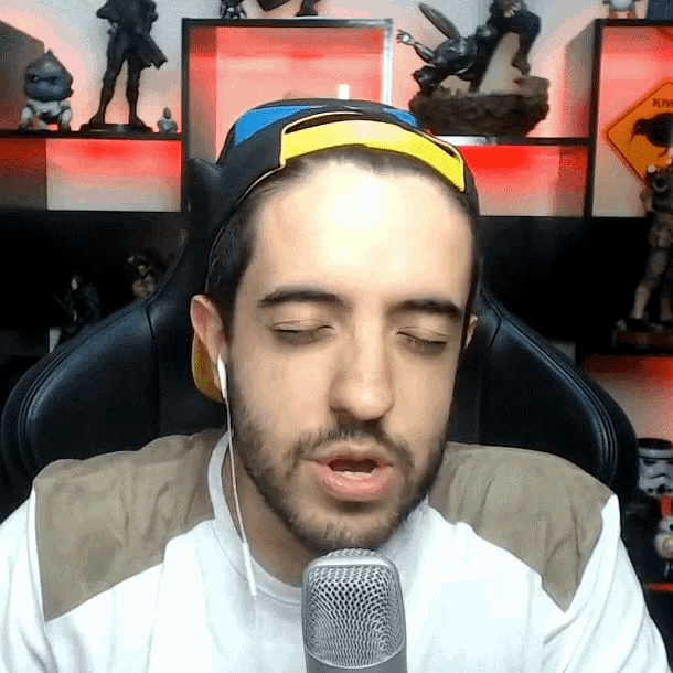 a man with a beard is wearing headphones and a headband while talking into a microphone