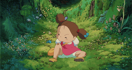 a little girl in a pink dress is sitting on the grass