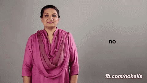 a woman in a pink shirt is standing in front of a wall .