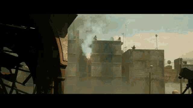 a man stands on top of a building watching smoke coming out of it