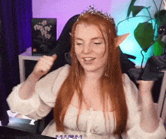 a woman with red hair and elf ears is wearing a crown and a white shirt