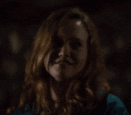a close up of a woman 's face with red hair