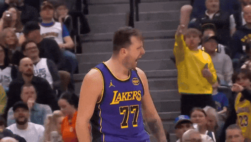 a basketball player wearing a purple lakers jersey celebrates in front of a crowd