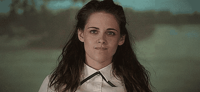 a close up of a woman wearing a white shirt and a black bow tie