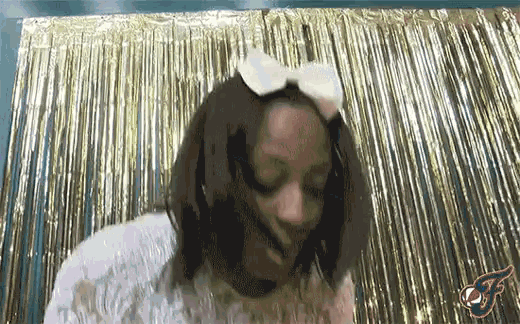 a woman wearing a white bow on her head is dancing