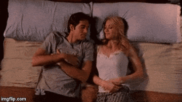 a man and a woman are hugging each other while laying in bed .