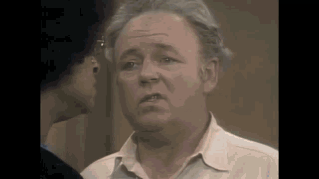 an older man is talking to another man in a room .