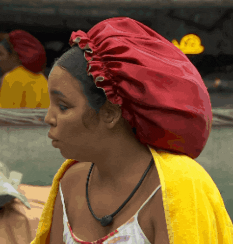 a woman wearing a red hat and a yellow blanket