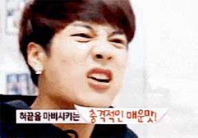 a young man making a funny face with korean writing on the bottom right