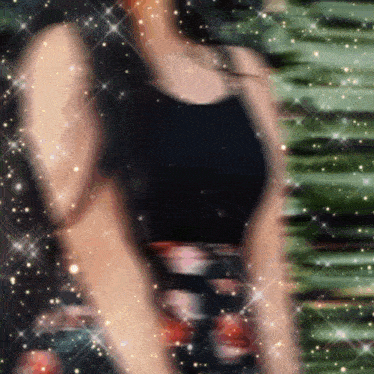 a blurry picture of a woman in a black top and floral skirt