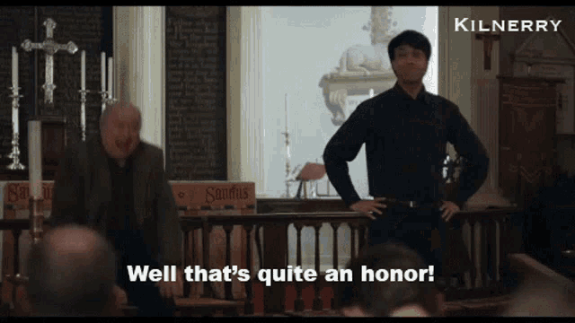 a man in a black shirt is standing in a church and says well that 's quite an honor