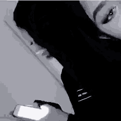 a black and white photo of two women looking at a phone