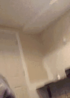 a person is sitting on a couch in a room with a door and a desk .
