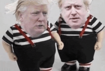 two dolls with their faces on them are standing next to each other .
