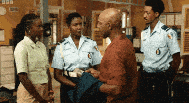 a group of police officers are talking to a man in a room with bbc written in the corner