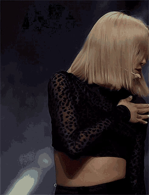 a woman wearing a black crop top with leopard print sleeves