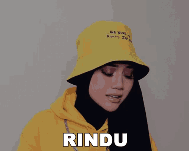 a woman wearing a yellow hat that says we play ready set go