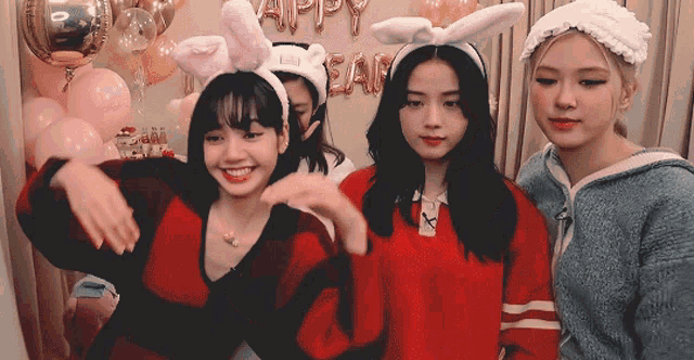 three girls wearing bunny ears are posing for a picture in front of balloons that say happy new year
