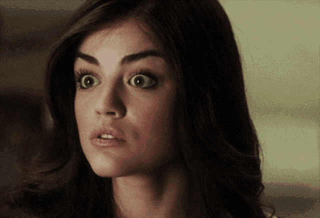 a close up of a woman making a surprised face .