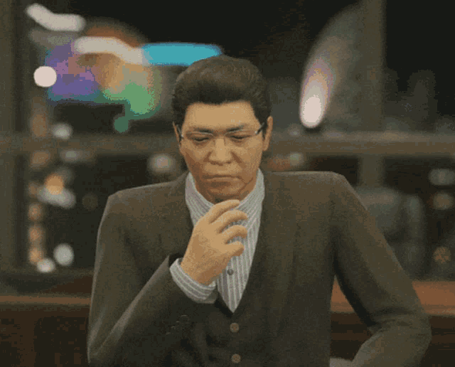 a man in a suit is giving a thumbs up sign