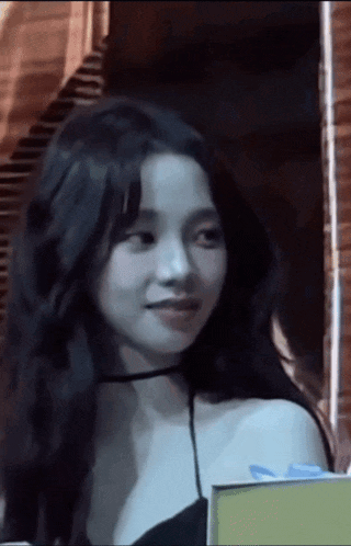 a woman with long black hair wearing a choker