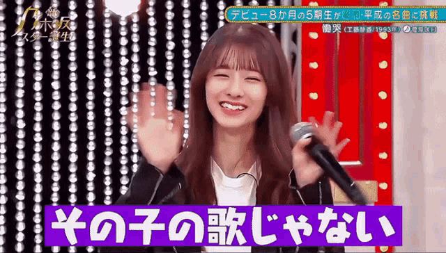 a girl singing into a microphone with a sign above her that says ' a '
