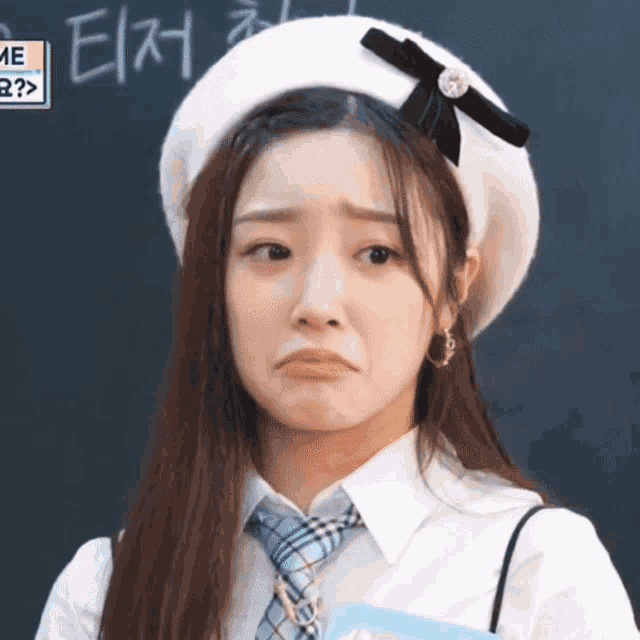 a girl wearing a beret and tie is making a funny face