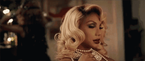 a woman is wearing a pearl necklace and a pearl bracelet .
