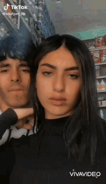 a man and a woman are standing next to each other and looking at the camera .
