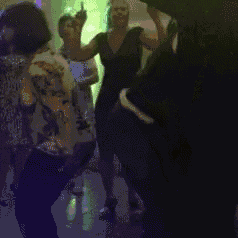 a group of people are dancing on a dance floor in a dark room .