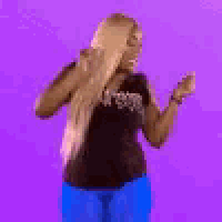 a woman with blonde hair is dancing on a purple background .