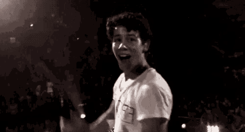 a black and white photo of a young man in a t-shirt with the letter f on it