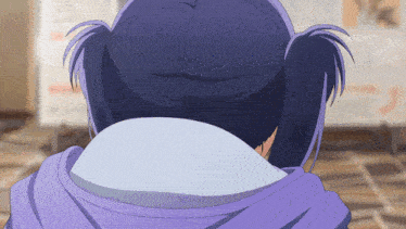 a girl with pigtails is wearing a purple sweatshirt