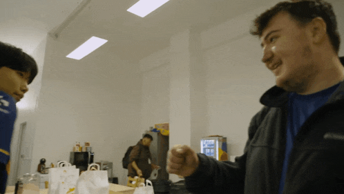 a man in a black jacket points at another man