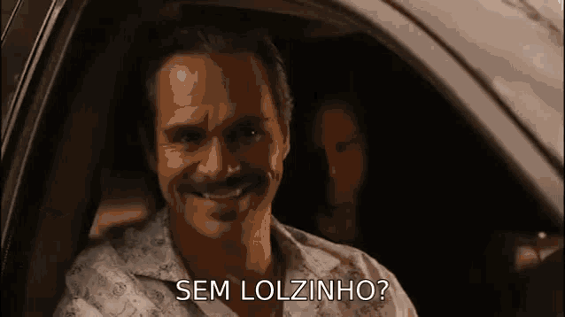 a man with a mustache is sitting in a car .