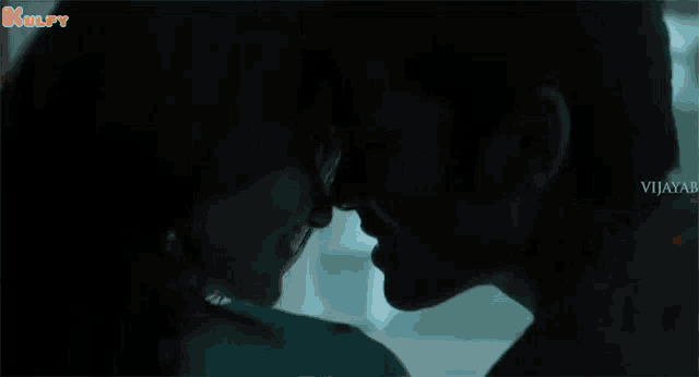 a close up of a man and woman kissing with the words kulfy visible